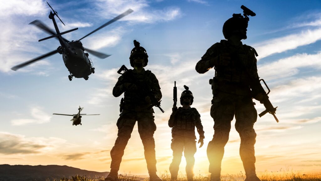 Silhouettes Of Soldiers During Military Mission At Sunset